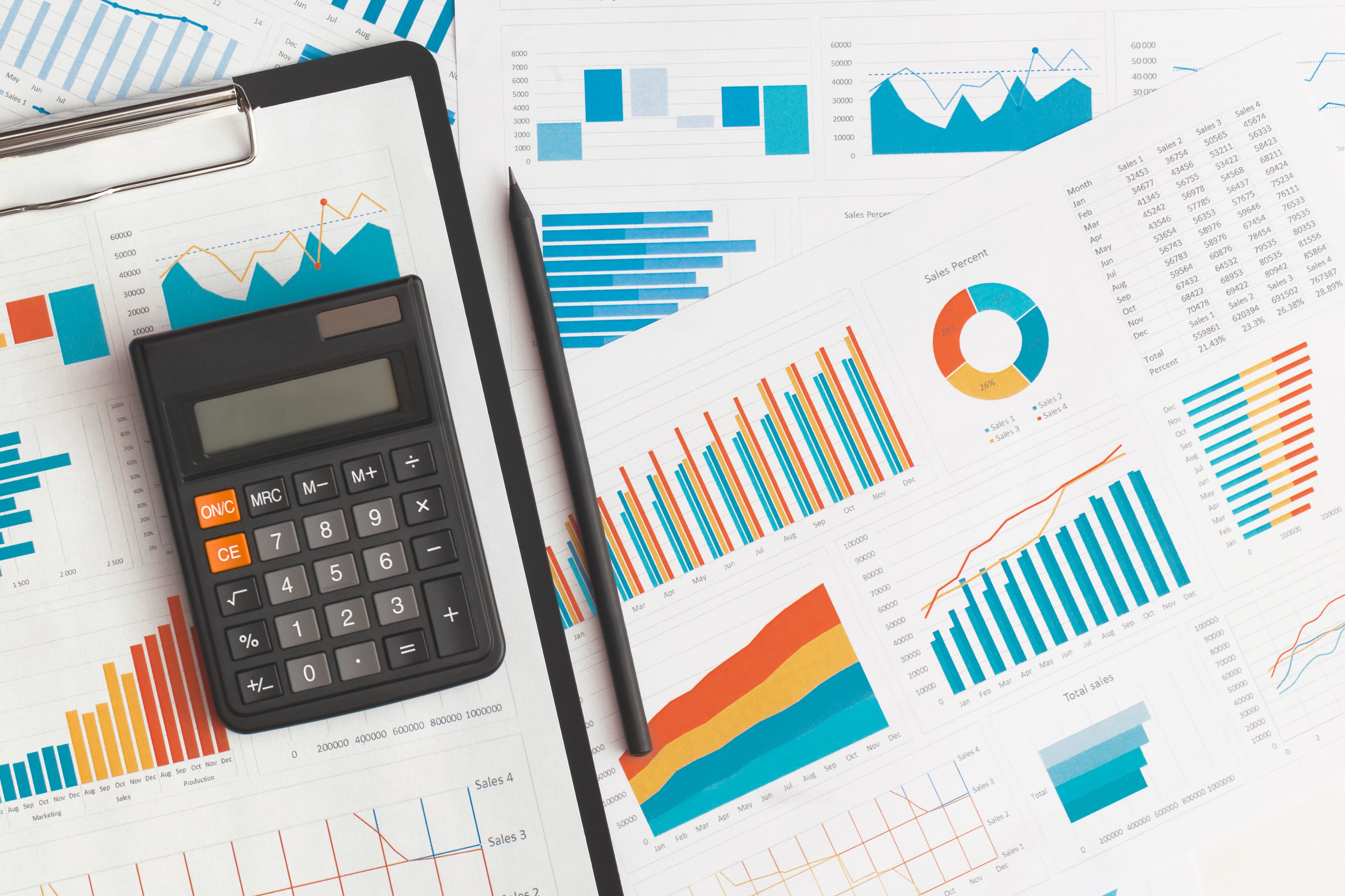 Business graphs, charts and calculator on table