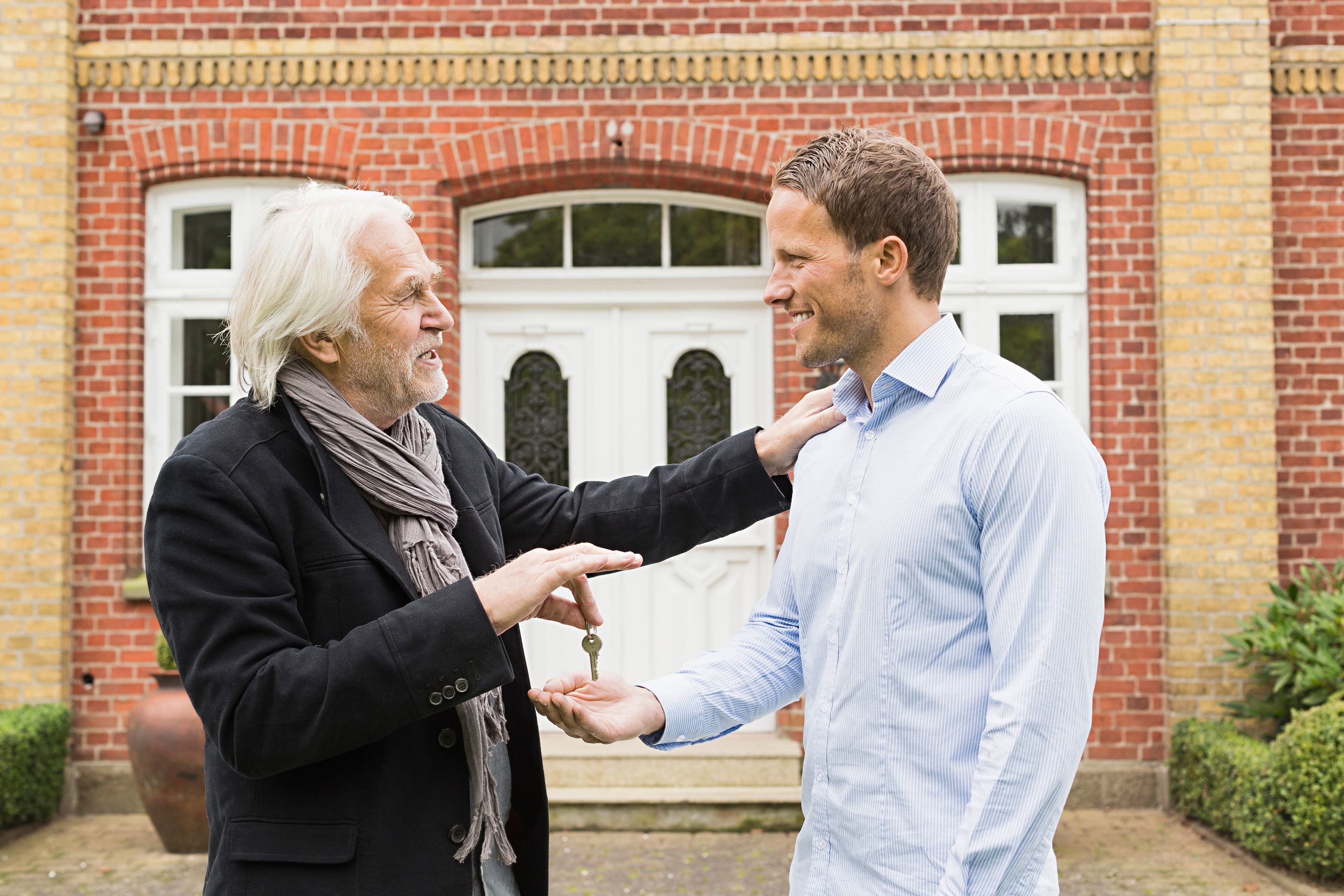 Father giving son a key outside their new home