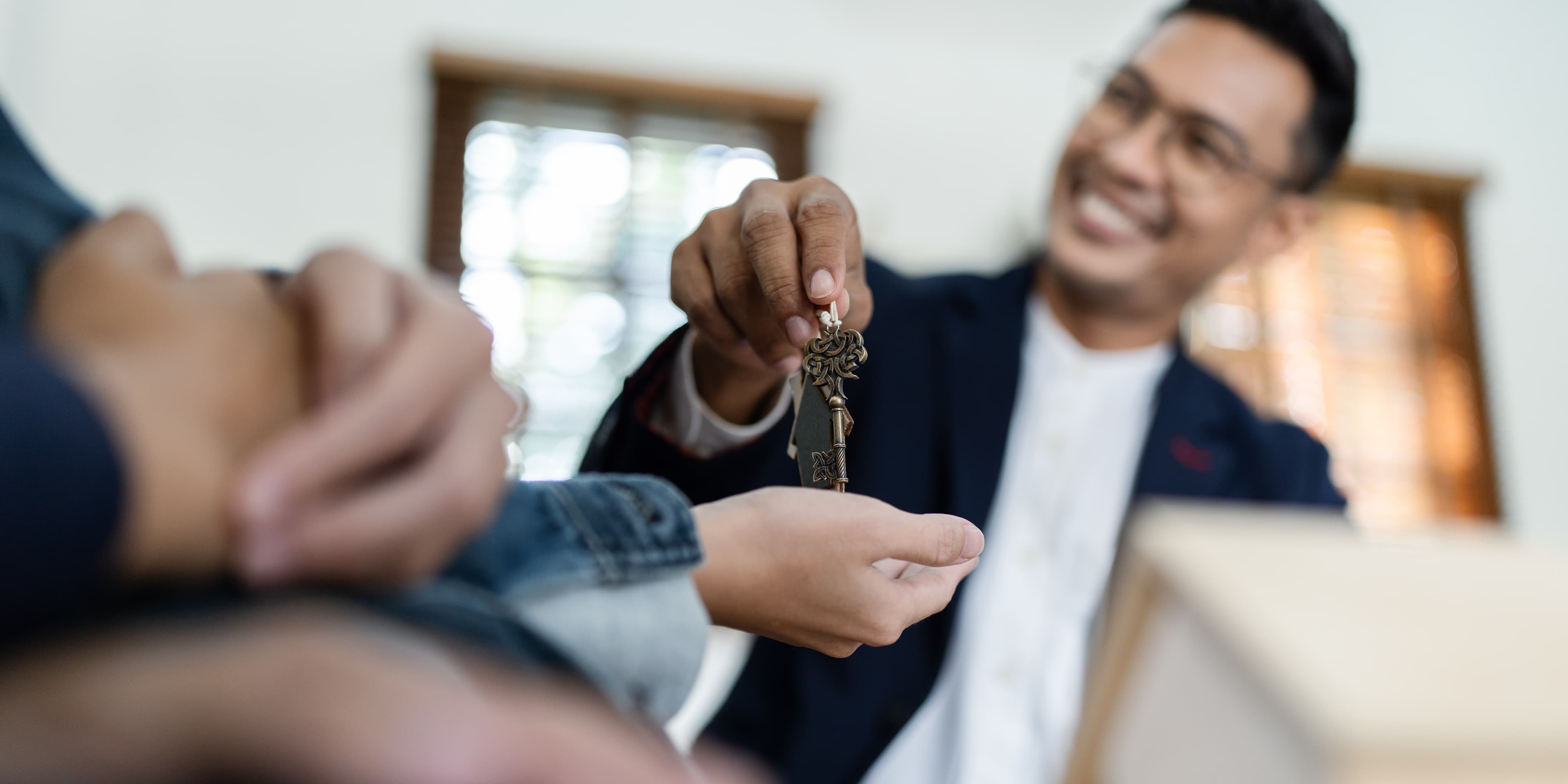 Happy agent giving keys to new homeowner