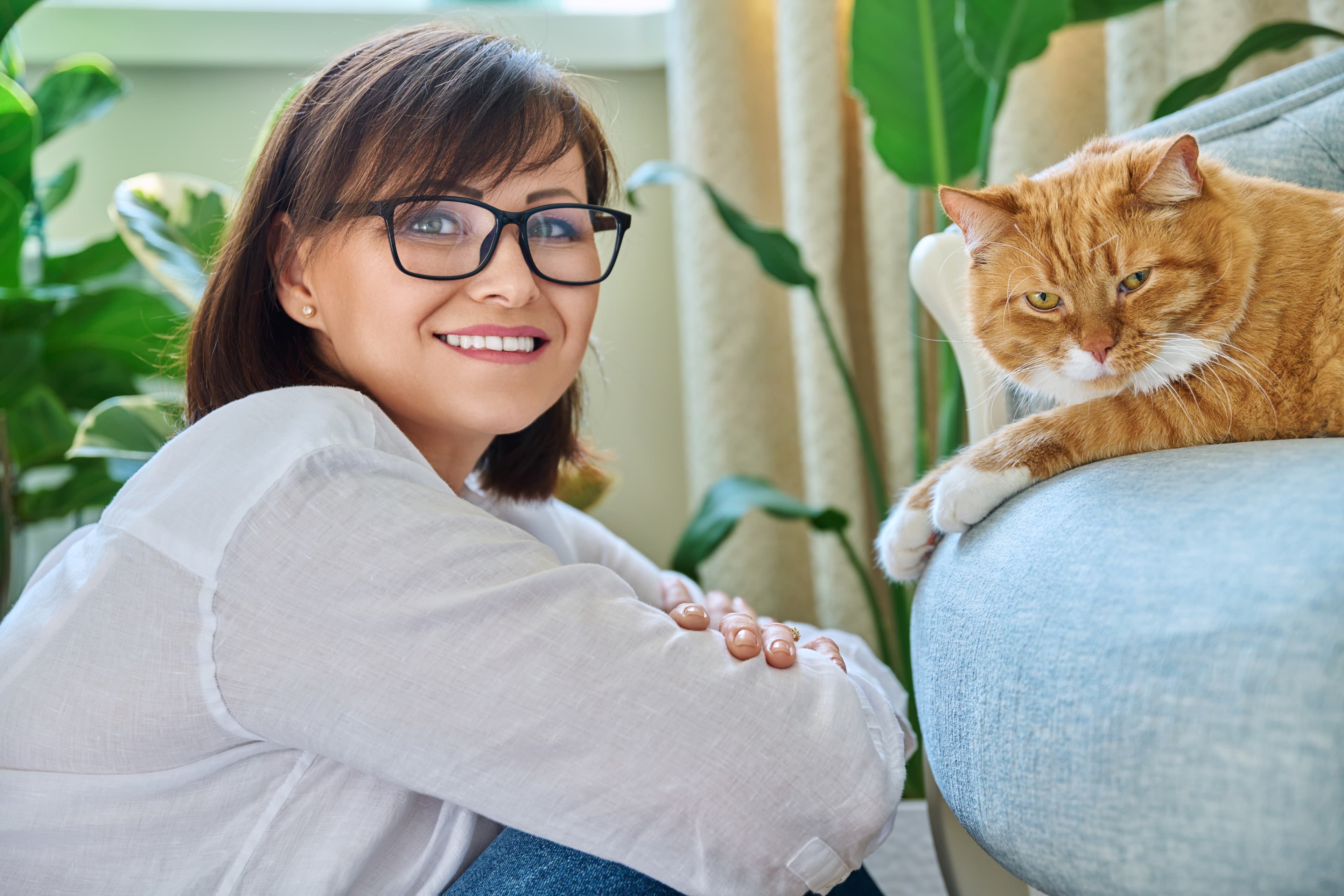 Smiling woman relaxing with pet cat