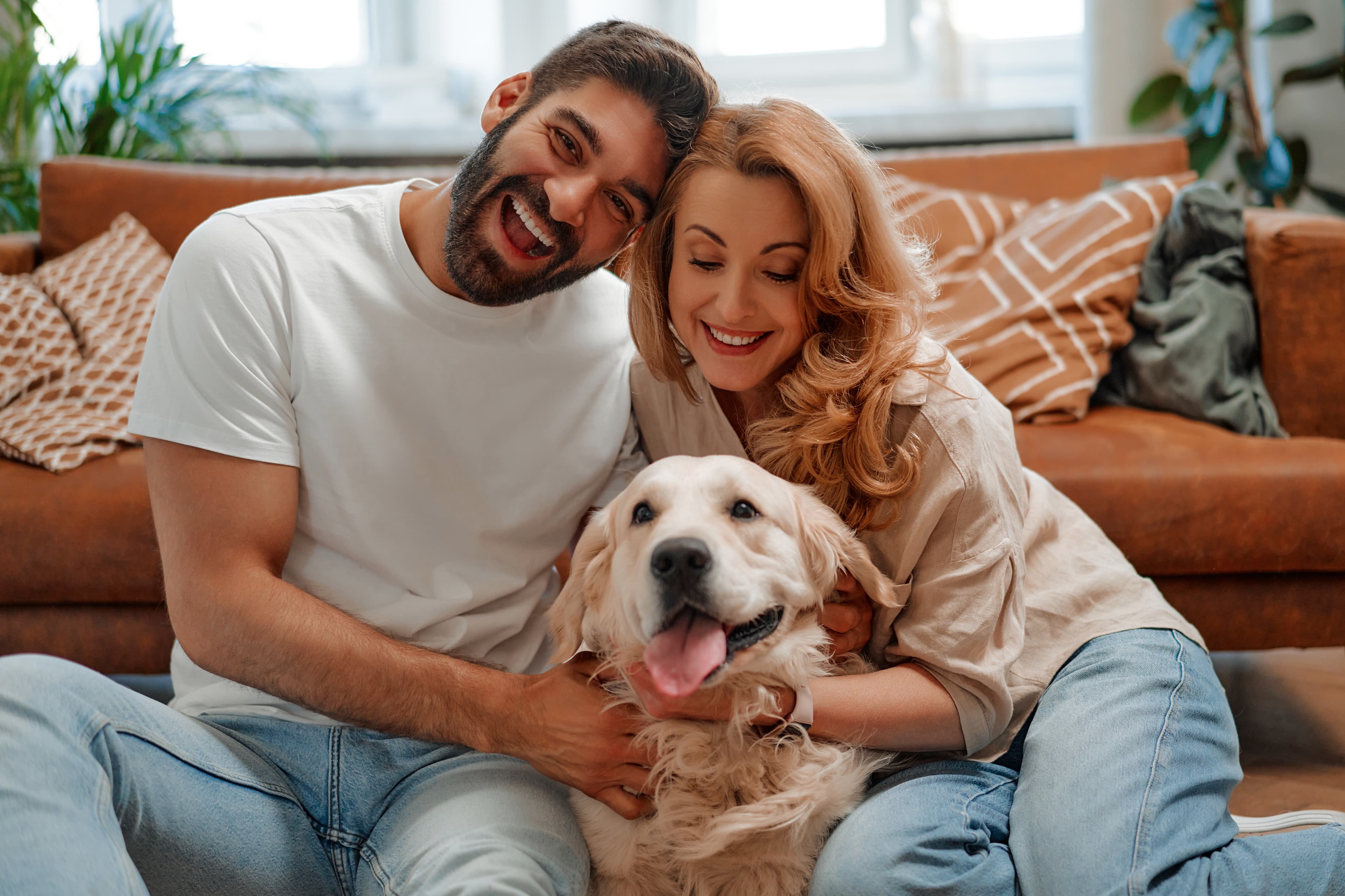 Couple relaxing at home with their pet dog