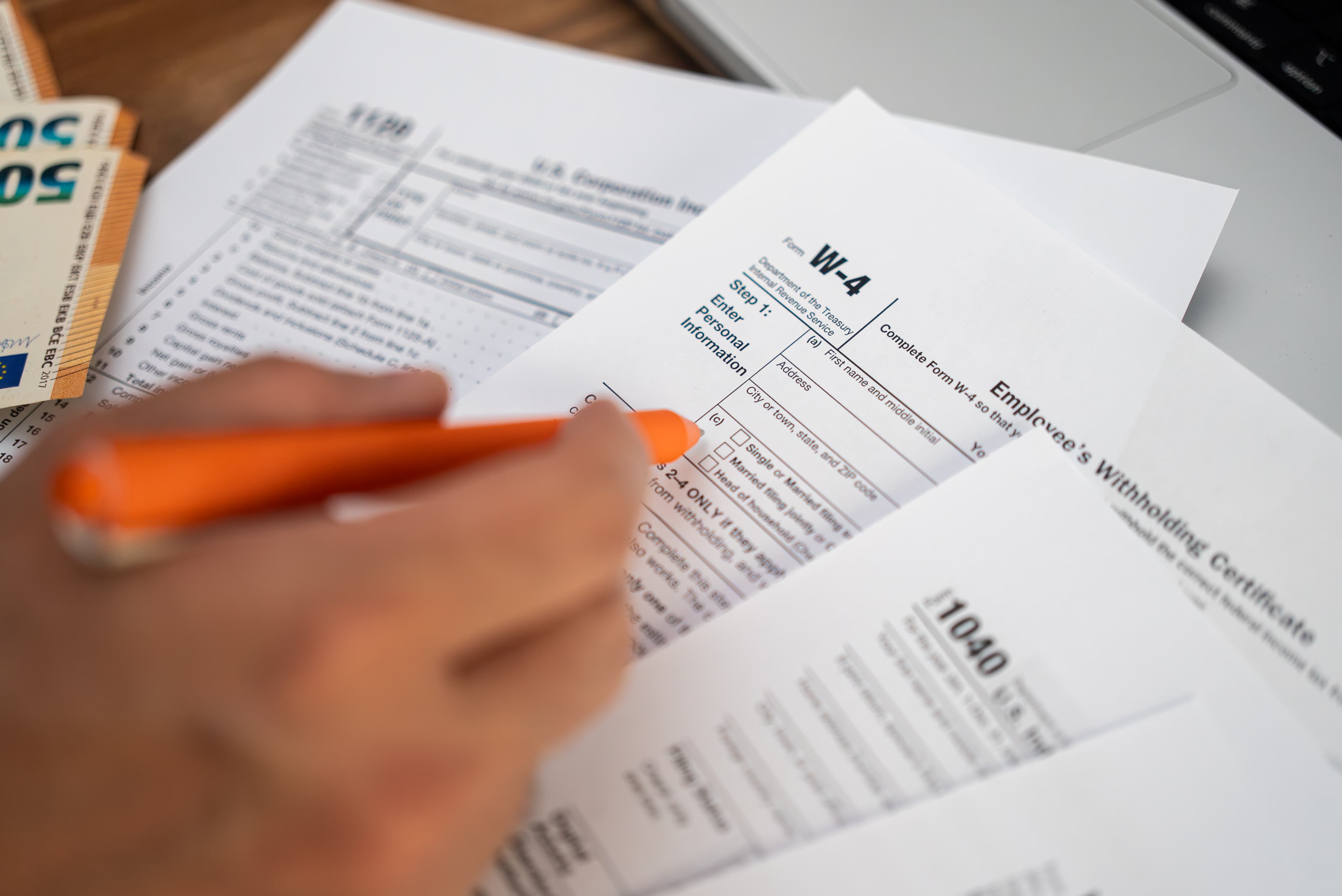 Person filling out W-4 tax form